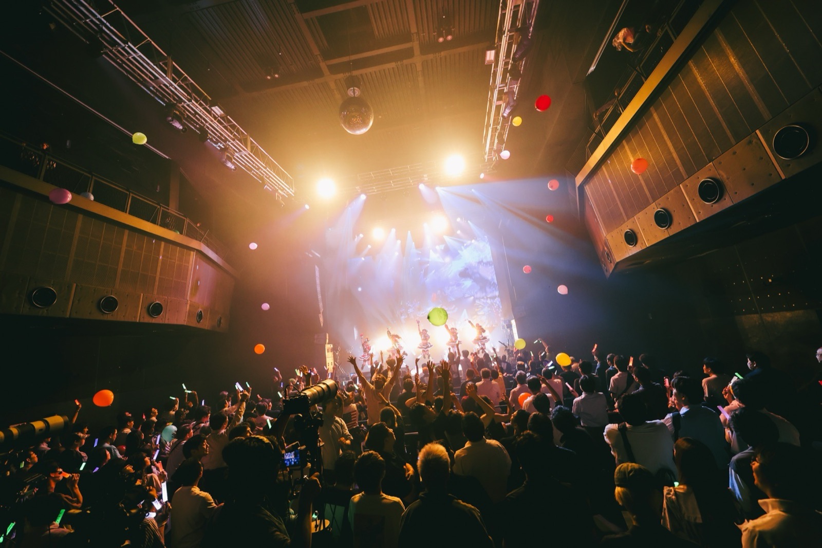 満員のライブ会場でステージを見上げる観客