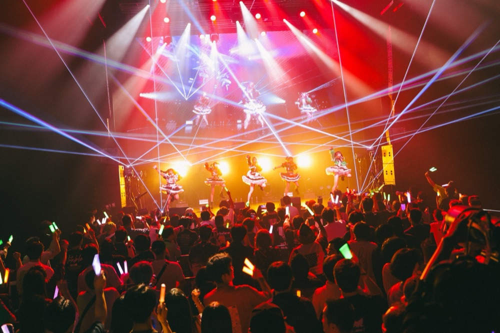 ライブ会場を埋める観客とレーザー演出